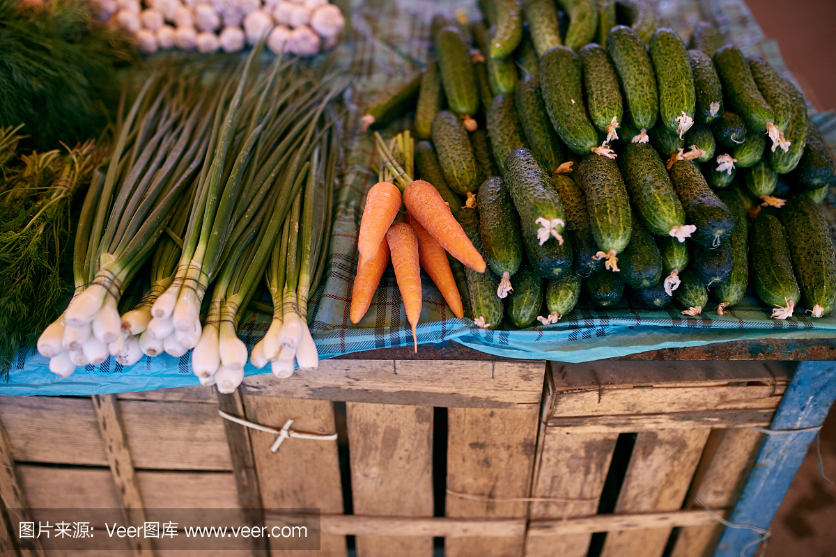 新鲜的有机蔬菜和水果在当地农民的户外夏季市场出售。健康有机食品理念。胡萝卜,大蒜和黄瓜